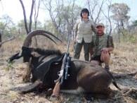 Proud hunters with a trophy Zambian sable