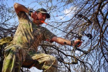Hunter shooting his bow in Namibia