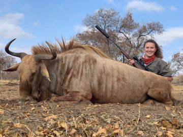 Huntress with a golden wildebeest trophy